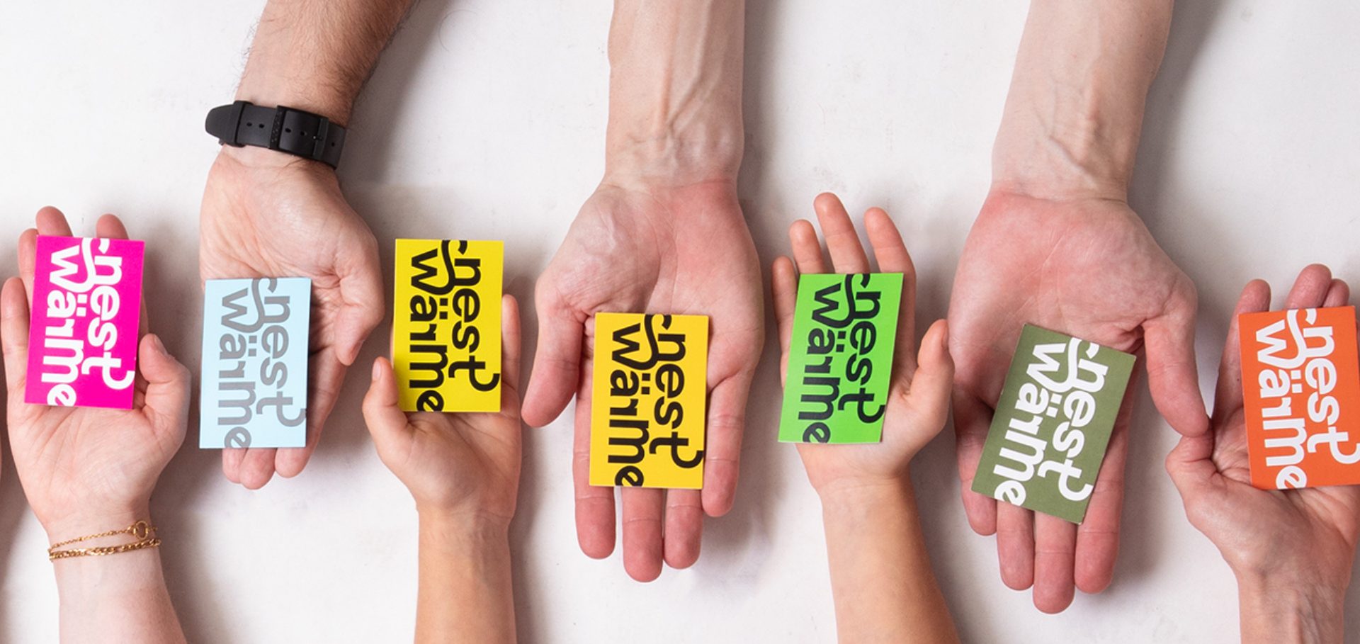 Hände, die Visitenkarten von Nestwärme halten